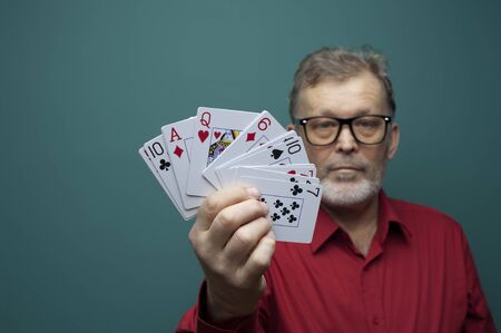 Elderly man showing a fan of poker cards.の写真素材