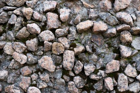 Close-up - gray-brown stone wall in the old facade of the house