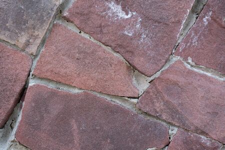 Close-up - brown stone wall in the old facade of the houseの写真素材
