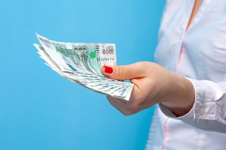 Hands of a young unidentified woman holding a pack of russian rublesの写真素材