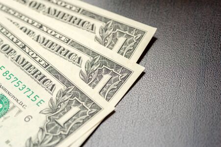 Paper dollar bills are lying on the tableの写真素材