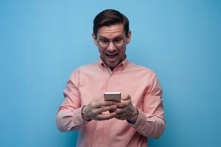 Portrait of a handsome young man in glasses with smartphone