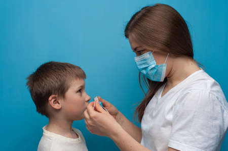 Portrait of caucasian mother and son wearing protective medical mask.