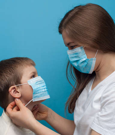 Portrait of caucasian mother and son wearing protective medical mask.の写真素材