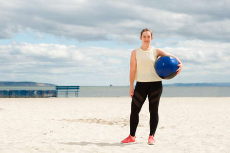 Athletic woman with medicine ball at outdoor fitness gym.の写真素材