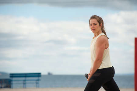 Portrait of positive woman wearing top and leggings warming up.の写真素材