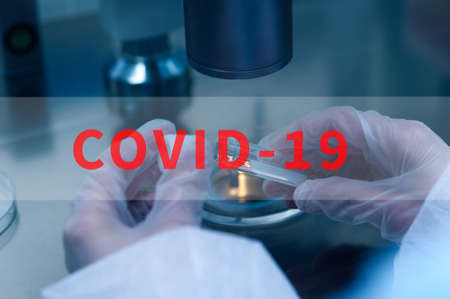 Closeup of microbiologists hand opening test tube with coronavirus vaccineの写真素材