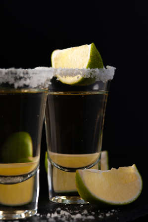 Shots of Mexican Gold Tequila with lime slices and salt.の写真素材