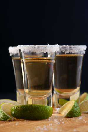 Shots of Mexican Gold Tequila with lime slices and salt.の写真素材