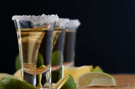 Shots of Mexican Gold Tequila with lime slices and salt.の写真素材