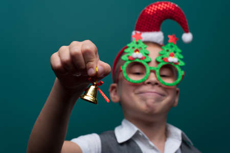 Portrait of happy little boy wearing headband with Santa Claus Hat and funny glasses with Christmas toysの写真素材