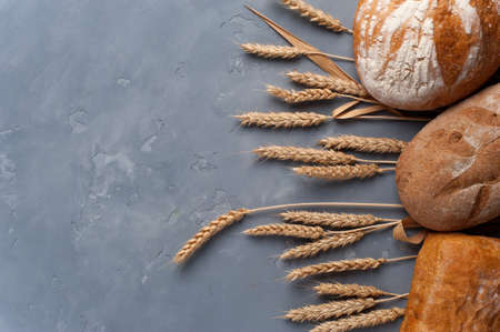 Freshly baked different breads on grey background.