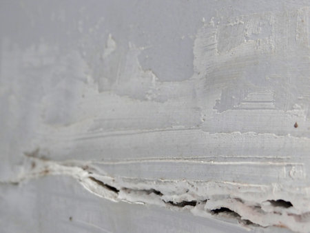 close up of a white wall with peeling paint, abstract backgroundの写真素材