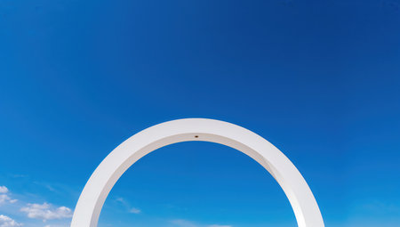 White arch with blue sky background. Abstract architectural background. Copy space.の素材