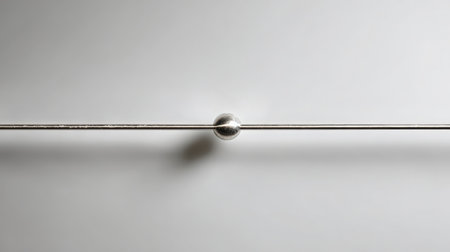 Close-up of a metal pendulum on a white background.の素材
