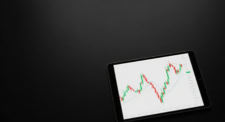 Tablet pc with stock market graph on screen on black background.の素材