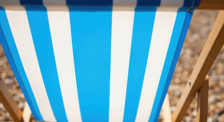 Blue and white striped deck chair on the beach. Close-up.の素材