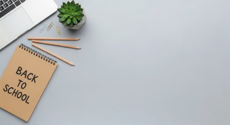 Top view of modern workplace with laptop, supplies and copy space on gray background.の素材
