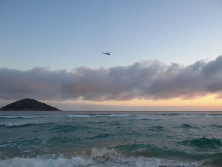 Tropical beach at sunset with helicopter in the skyの写真素材