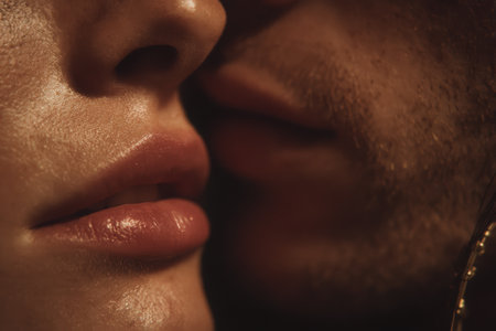a close up shows two faces in very close proximity. the skin appears sweaty and the lips are full. the image conveys intimacy and connection between the two individuals. the scene is dimly lit.の素材