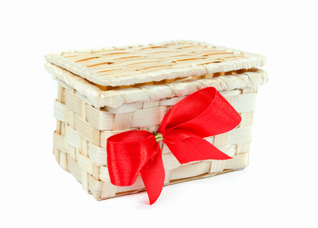 Wicker wood gift box on a white background with a festive red bow.の写真素材