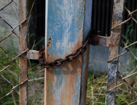 Metal gates are locked with a rusty chain 