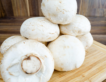 Field mushrooms on a cutting board on a wooden tableの写真素材