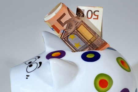  Piggy bank with 50 euros denomination bill in its slot の写真素材