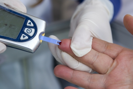 Measuring blood sugar with a blood glucose meterの写真素材