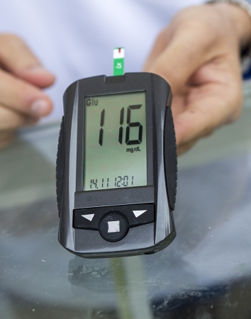 Measuring blood sugar with a blood glucose meterの写真素材