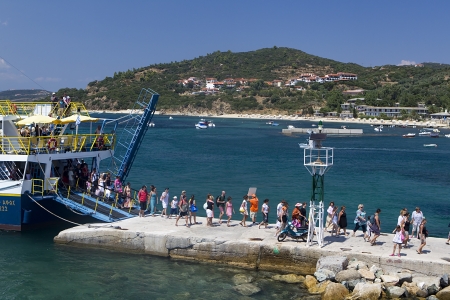 OURANOUPOLI, GREECE - AUGUST 12: Tourists descend from ferry in port of Ouranoupoli village near the Mount Athos on August 12, 2012 in Ouranoupoli, Greeceのeditorial素材