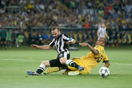KHARKIV, UKRAINE -AUG 07:Salpingidis of PAOK (L) in action with Moledo of METALIST (R) during the UEFA Champions League soccer match METALIST vs PAOK at Metalist Arena on August 07,2013 in Kharkiv, Ukraine.のeditorial素材