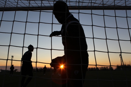 THESSALONIKI, GREECE - JANUARY 3: Silhouettes of soccer players of PAOK Thessaloniki team during training background on the sunset sky at Mesimvria stadium on January 3, 2013 in Thessaloniki, Greeceのeditorial素材