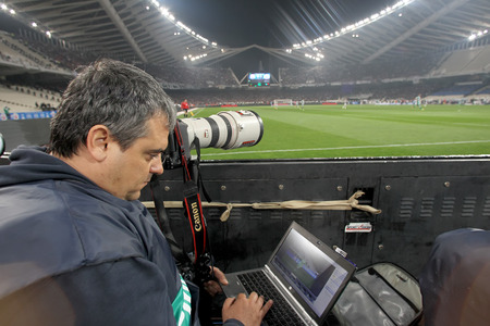ATHENS, GREECE APRIL 26, 2014 : A photographer working during the Greek Cup Final match Paok vs Panathinaikosのeditorial素材