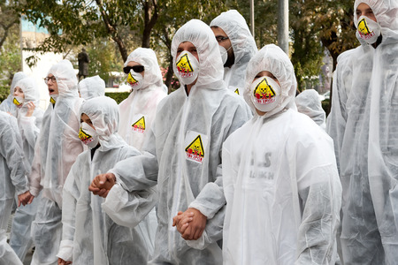 THESSALONIKI, GREECE- NOVEMBER 24, 2012: Protesters wearing chemical protective suits hold hands. Protest against gold mining in Stratoni, Halkidiki. The protest took place in Thessaloniki, Greece.のeditorial素材