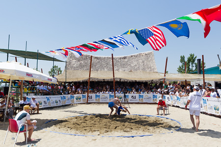 KATERINI, GREECE- JULY 6, 2014: Two male athletes wrestle on sand during the First World Championship Beach Wrestling in 2014 in Katerini, Greece. のeditorial素材