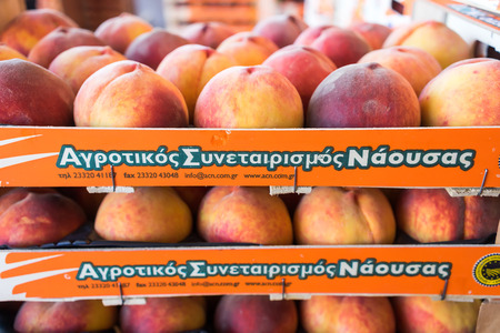 NAOUSSA, GREECE- JULY 10, 2014: Products of Agricultural Cooperative of Naoussa, Greece, stacked in boxes. The famous "Naoussa Peaches", are the areaâs main product. Fruit production.のeditorial素材