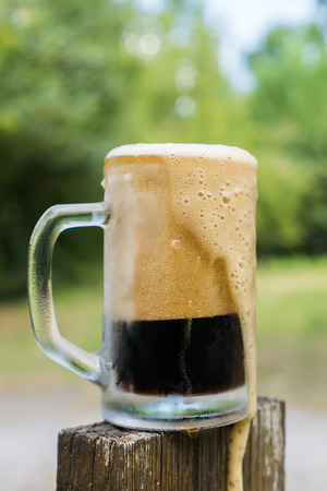 Glass of black beer in nature backgroundの写真素材
