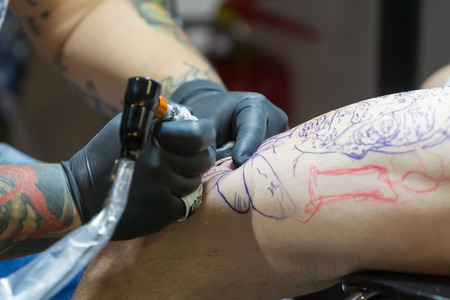 THESSALONIKI, GREECE- SEPTEMBER 19, 2014: Tattoo artist works in The 1st Thessalonink International Tattoo Convention, in Greece. Convention was held in Thessaloniki Port Warehouse C.のeditorial素材