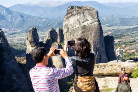 METEORA, GREECE - OCTOBER 12, 2014: Tourists taking pictures during their tour at Meteora, Greece.のeditorial素材
