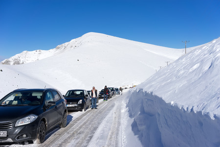 FALAKRO, GREECE - FEBRUARY 11, 2013: Visitors waiting near their cars for the Snowmobile to remove the snow from the road in Falakro, Greece. Falakro Mountain is located in the area of Dramas.のeditorial素材