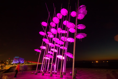 THESSALONIKI, GREECE- OCTOBER 21, 2014: Umbrellas of Thessaloniki, Greece. The sculpture was illuminated with the color that symbolizes breast cancer to raise awareness about the disease.のeditorial素材