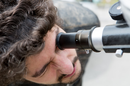 THESSALONIKI, GREECE, MARCH 20, 2015: People watch through a telescope into the sky at a partial solar eclipse. Over Greece  the moon was scheduled to cover approximately 45% of the sun for a short period.のeditorial素材