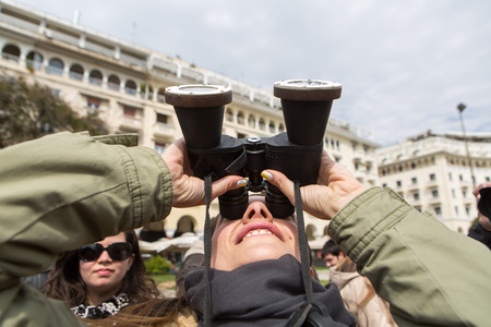 THESSALONIKI, GREECE, MARCH 20, 2015: People use binoculars with special filters to look into the sky at a partial solar eclipse. Over Greece the moon was scheduled to cover approximately 45%.のeditorial素材