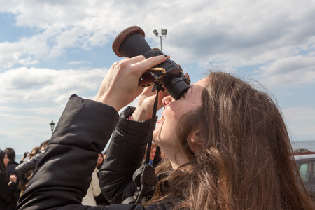 THESSALONIKI, GREECE, MARCH 20, 2015: People use binoculars with special filters to look into the sky at a partial solar eclipse. Over Greece the moon was scheduled to cover approximately 45%.のeditorial素材