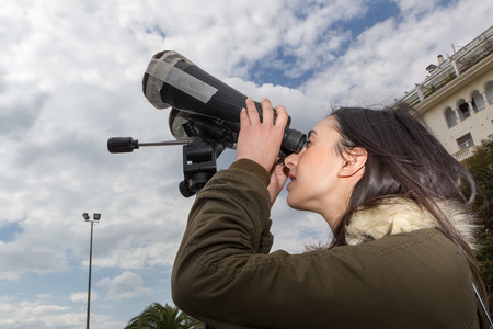 THESSALONIKI, GREECE, MARCH 20, 2015: People use binoculars with special filters to look into the sky at a partial solar eclipse. Over Greece the moon was scheduled to cover approximately 45%.のeditorial素材