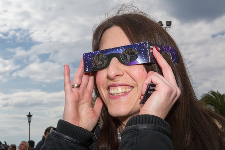 THESSALONIKI, GREECE, MARCH 20, 2015: People use special glasses to look into the sky at a partial solar eclipse. Over Greece the moon was scheduled to cover approximately 45%.のeditorial素材