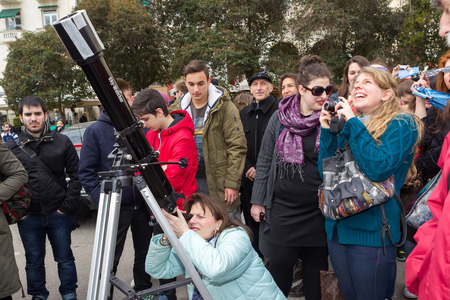 THESSALONIKI, GREECE, MARCH 20, 2015: People watch through a telescope into the sky at a partial solar eclipse. Over Greece  the moon was scheduled to cover approximately 45% of the sun for a short period.のeditorial素材