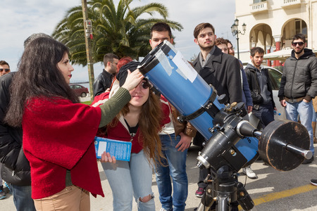 THESSALONIKI, GREECE, MARCH 20, 2015: People watch through a telescope into the sky at a partial solar eclipse. Over Greece  the moon was scheduled to cover approximately 45% of the sun for a short period.のeditorial素材