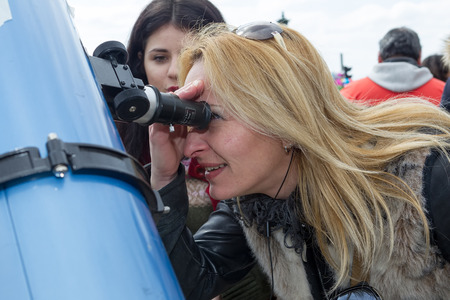 THESSALONIKI, GREECE, MARCH 20, 2015: People watch through a telescope into the sky at a partial solar eclipse. Over Greece  the moon was scheduled to cover approximately 45% of the sun for a short period.のeditorial素材